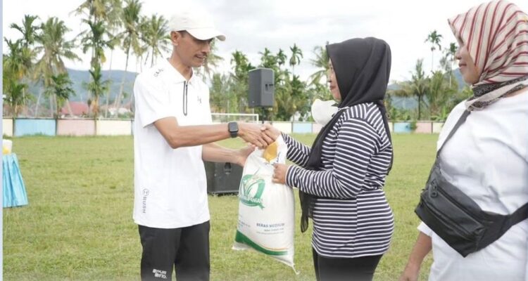 SERAHKAN BANTUAN—Wabup Solsel Yulian Efi menyerahkan bantuan pangan saat pelaksanaan Car Free Day (CFD)  di Lapangan Bola Pakan Rabaa, Kec. KPGD, Minggu (15/12) pagi.