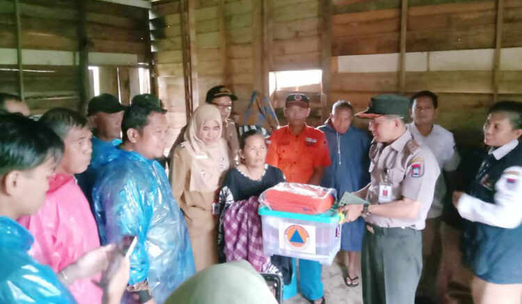 BANTUAN— Warga yang rumahnya rusak akibat puting beliung di RT 04/RW 05, Koto Parak, Kelurahan Pisang, Kecamatan Pauh, Senin (23/12) sekitar pukul 12.00 WIB lalu, menerima bantuan dari BPBD dan Dinas Sosial.