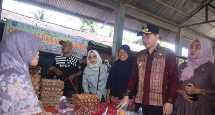 TINJAU—Pj Wako Sawahlunto Fauzan Hasan didampingi  Kepala Dinas Ketahanan Pangan Pertanian dan Perikanan (DKP3) Kota Sawahlunto Heni Purwaningsih, tinjau  operasi pasar pangan murah.