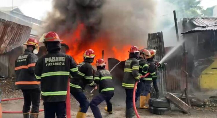 KEBAKARAN— Petugas Damkar melakukan penyemprotan air untuk memadamkan api yang membakar gudang rongsokan dan bengkel motor di Kecamatan Lubuk Begalung.