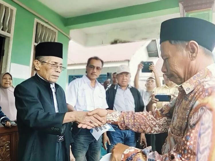 BERIKAN BANTUAN— Ketua KUD Tiku Lima Jorong Kecamatan Tanjung
Mutiara AM Dt Bandaharo membantu ribuan warga Tiku Limo Jorong
Kecamatan Tanjung Mutiara, Senin (13/1).