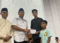 SANTUNAN—Wakil Gubernur Sumatera Barat, Vasko Ruseimy, serahkan santunan beasiswa pada salah seorang murid.