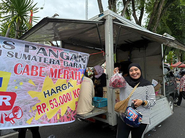 PASAR MURAH—Salah satu masyarakat memperlihatkan cabai merah yang dibelinya di Pasar Murah Cabai Merah di CFD Padang.