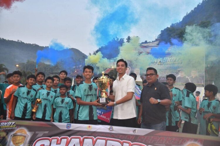 SERAHKAN PIALA— Wali Kota Riyanda Putra  serfahkan tropi pada pemenang saat penutupan, Turnamen Sepak Bola Askot PSSI Sawahlunto tingkat SMP sederajat di Lapangan Ombilin, Kamis (9/10).