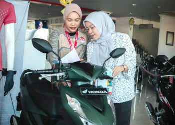 LAYANI KONSUMEN-Sales marketring PT Menara Agung melayani konsumen yang melakukan pembelian New Honda BeAT.